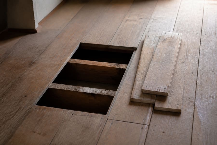 A section of damaged floorboards lifted out beside sound boards